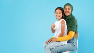 A child sits on her mother's lap after getting vaccinated